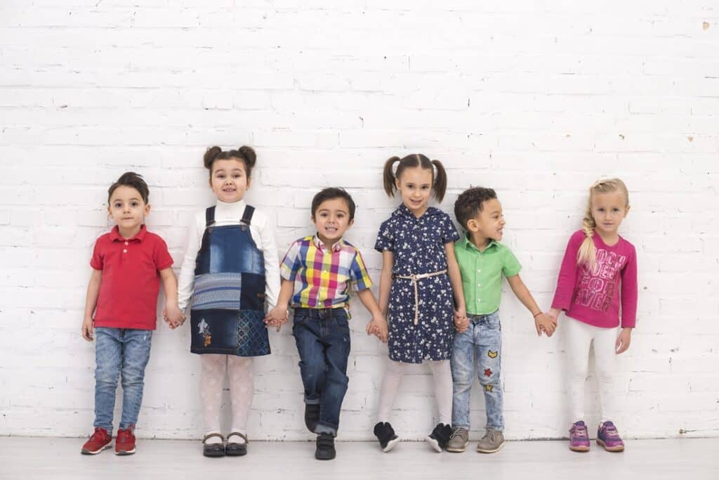 קבוצת ילדים לבושים בבגדים שונים עומדת ומחייכת למצלמה